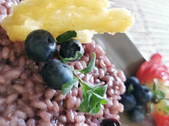 Risotto con mirtilli, fragolino, timo, cialda di grana e salsa al grana e zafferano