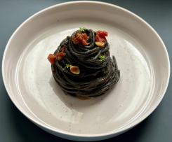 Spaghetti al nero con sugo di acciughe, basilico greco e bottarga