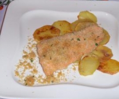 Salmone impanato al forno adagiato su un letto di patate