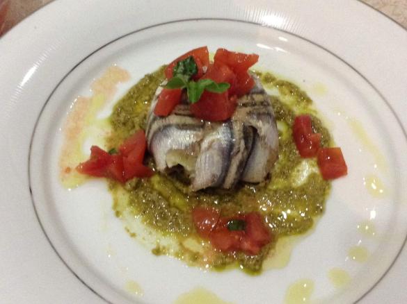 Tortino di alici ripieno su fondo di pesto e pomodorini